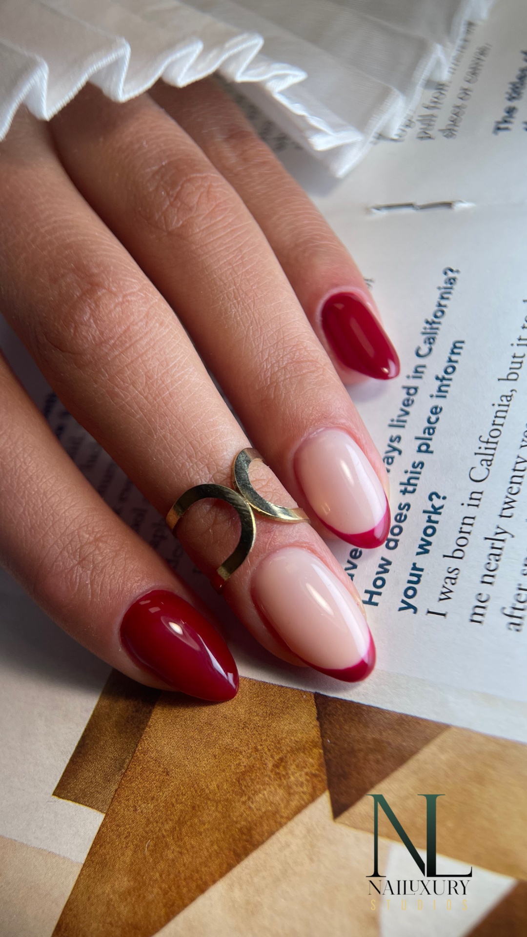 Red french tip almond nails with gold accent